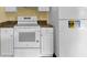 White appliances and granite countertops in kitchen at 4611 Gate Pl # H-203, Orlando, FL 32811