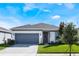 One story home with gray garage door and landscaped lawn at 2195 Bluebird Pl, St Cloud, FL 34771