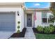 Gray house with a gray garage door, American flag, and well-manicured landscaping at 2195 Bluebird Pl, St Cloud, FL 34771