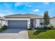 One-story home with gray garage door and landscaped lawn at 2195 Bluebird Pl, Saint Cloud, FL 34771