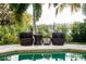 Poolside seating with a picturesque view of the lake at 5126 Fairway Oaks Dr, Windermere, FL 34786