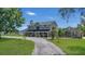 Two-story home with a circular driveway, landscaping and detached garage at 3105 Pastures Rd, Kissimmee, FL 34746