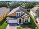 Two-story tan house with a white garage and brick driveway at 133 Andalusia Loop, Davenport, FL 33837