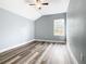 Simple bedroom with window, wood-look floors and ceiling fan at 133 Andalusia Loop, Davenport, FL 33837