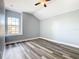 Well-lit bedroom with wood-look floors and a large window at 133 Andalusia Loop, Davenport, FL 33837