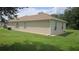 Tan house with brown roof, white gutters, and a large grassy yard at 627 N Delmonte Ct, Kissimmee, FL 34758