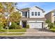 Two-story house with gray siding, stone accents, and a three-car garage, tree in front at 3425 Halsway Dr, Orlando, FL 32824