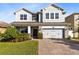 Two-story house with gray siding, stone accents, and a three-car garage at 3425 Halsway Dr, Orlando, FL 32824