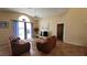Living room with access to the pool, featuring brown couches and a large TV at 3011 Bransbury Ct, Kissimmee, FL 34747