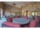 Community patio with round table and chairs, stone wall, and ceiling fans at 907 Charo Pkwy # 933, Davenport, FL 33897