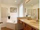Bathroom with corner bathtub, shower, and wood vanity at 256 Sevilla Ave, Davenport, FL 33897