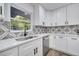 Modern kitchen with white cabinets, a stylish backsplash and black faucet at 715 Eastover Cir, Deland, FL 32724