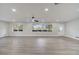Bright living room featuring hardwood floors, ceiling fan, and large windows at 715 Eastover Cir, Deland, FL 32724