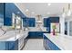 Modern kitchen with blue cabinets, marble countertops, and an island at 6053 New Hope Rd, Orlando, FL 32824