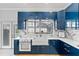 Modern kitchen with farmhouse sink, marble countertops, and blue cabinets at 6053 New Hope Rd, Orlando, FL 32824