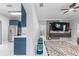 Living room with blue kitchen cabinets, patterned rug, and large flat-screen TV at 6053 New Hope Rd, Orlando, FL 32824