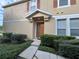 House exterior with a brown door and manicured shrubs at 10791 Gran Paradiso Dr # S, Orlando, FL 32832