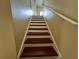 Indoor staircase with dark wood steps and white risers, featuring a white handrail at 10791 Gran Paradiso Dr # S, Orlando, FL 32832