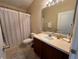Clean bathroom with a vanity, shower/tub combo, and striped shower curtain at 10791 Gran Paradiso Dr # S, Orlando, FL 32832