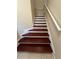 Indoor staircase with dark wood steps and white risers, featuring a white handrail at 10791 Gran Paradiso Dr # S, Orlando, FL 32832