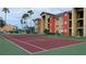 Well-maintained tennis court with maroon surface and green border at 2210 Grand Cayman Ct # 1722, Kissimmee, FL 34741