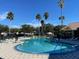 Sparkling community pool surrounded by palm trees at 2210 Grand Cayman Ct # 1722, Kissimmee, FL 34741