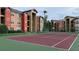 Well-maintained tennis court with maroon surface and green border at 2210 Grand Cayman Ct # 1722, Kissimmee, FL 34741