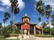 Community clubhouse with a fountain and palm trees at 2210 Grand Cayman Ct # 1722, Kissimmee, FL 34741