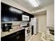 Well-equipped kitchen with granite countertops and dark cabinets at 2210 Grand Cayman Ct # 1722, Kissimmee, FL 34741