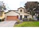 Two-story house with orange garage door and well-manicured lawn at 133 Alfani St, Davenport, FL 33896