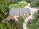 Brick house with gray roof, large driveway, and mature trees at 6365 Whip O Will E Ln, St Cloud, FL 34771