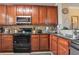 Well-equipped kitchen featuring wood cabinets and granite countertops at 901 Charo Pkwy # 721, Davenport, FL 33897