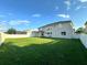 Spacious backyard with grassy lawn, white fence, and home view at 2321 Hinsdale Dr, Kissimmee, FL 34741