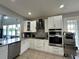 Modern kitchen with white cabinets, granite counters, and stainless steel appliances at 2321 Hinsdale Dr, Kissimmee, FL 34741