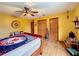 Bedroom with wood flooring, ceiling fan, and double doors to closet at 4155 Quail Wood Dr, St Cloud, FL 34772