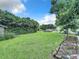 Spacious backyard with lush green grass and mature trees at 4155 Quail Wood Dr, St Cloud, FL 34772