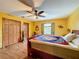 Bedroom with wood flooring, ceiling fan, and double doors to closet at 4155 Quail Wood Dr, St Cloud, FL 34772