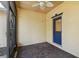 Covered porch with brick flooring, ceiling fan and a blue door at 196 Ventana Dr, Poinciana, FL 34759