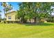 Spacious backyard with lush lawn, palm trees, and screened patio at 196 Ventana Dr, Poinciana, FL 34759
