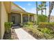 Inviting front entrance with a paved walkway, lush landscaping, and screened porch at 196 Ventana Dr, Poinciana, FL 34759