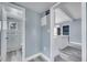 Hallway leading to the bathroom and kitchen, with gray-blue walls and wood-look flooring at 4810 Burgundy Ln, Orlando, FL 32808