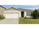 Tan one-story house with white garage door and blue shutters at 1286 Iguana Loop, Davenport, FL 33897