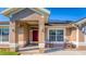 Front porch with red door and rocking chairs; solar panels on roof at 2090 Big Buck Dr, St Cloud, FL 34772