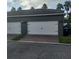 Two-car garage with white doors and brick paver driveway at 13155 Kegan St, Windermere, FL 34786
