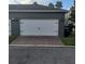 Two-car garage with white doors and brick paver driveway at 13155 Kegan St, Windermere, FL 34786