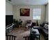 Cozy living room featuring a sectional sofa, a large TV, and various plants at 13155 Kegan St, Windermere, FL 34786