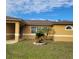 Tan house with brown roof, landscaping, and a covered entryway at 1325 Dunbarton Ct, Kissimmee, FL 34758
