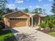 Tan house with two-car garage and attractive landscaping at 350 Balboa Dr, Kissimmee, FL 34759