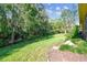 Landscaped backyard with a grassy area and trees at 350 Balboa Dr, Kissimmee, FL 34759