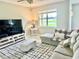 Living room with large TV, comfy seating, and a view of the pond at 3040 Palermo Rose Way, Kissimmee, FL 34746